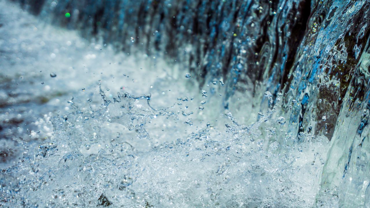 Close-up of water splashing with droplets in motion, showcasing nature's dynamic beauty.